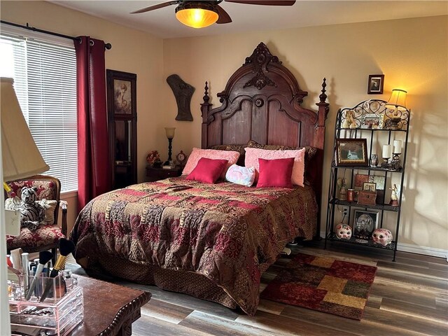 bedroom featuring multiple windows, wood-type flooring, and ceiling fan