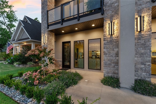 exterior entry at dusk featuring a balcony