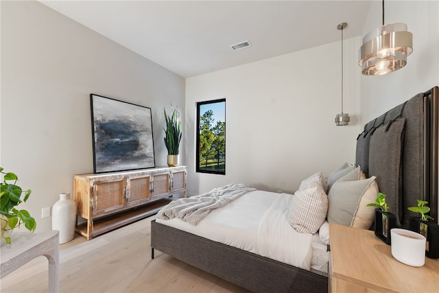 bedroom featuring light hardwood / wood-style flooring and an inviting chandelier