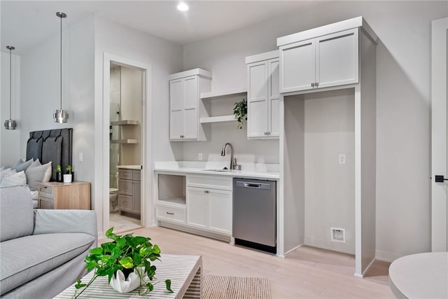 kitchen with white cabinets, pendant lighting, light hardwood / wood-style floors, and stainless steel dishwasher