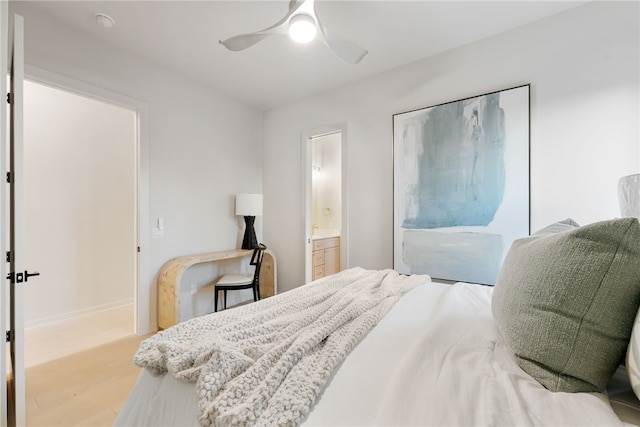 bedroom featuring light wood-type flooring, ceiling fan, and connected bathroom