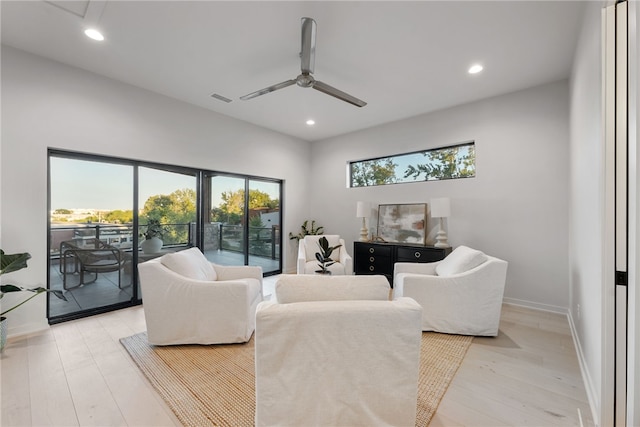 living room featuring ceiling fan and light hardwood / wood-style floors