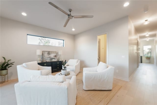 living room featuring ceiling fan and light hardwood / wood-style floors