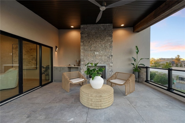 balcony at dusk featuring ceiling fan