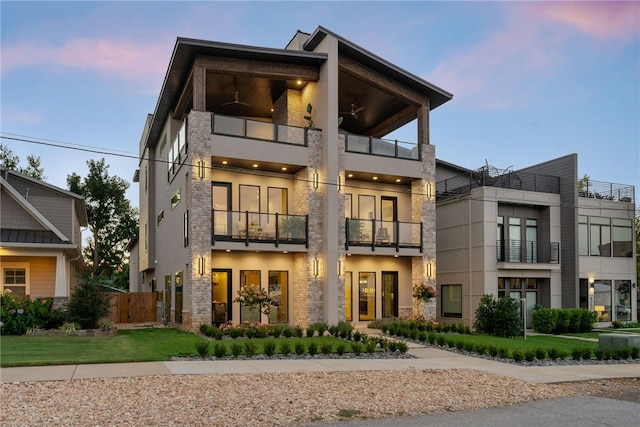 view of front facade with a balcony and a lawn