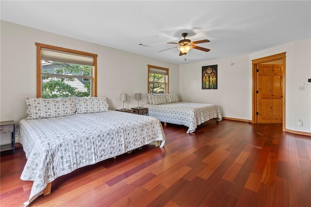 bedroom featuring visible vents, baseboards, a ceiling fan, and wood finished floors