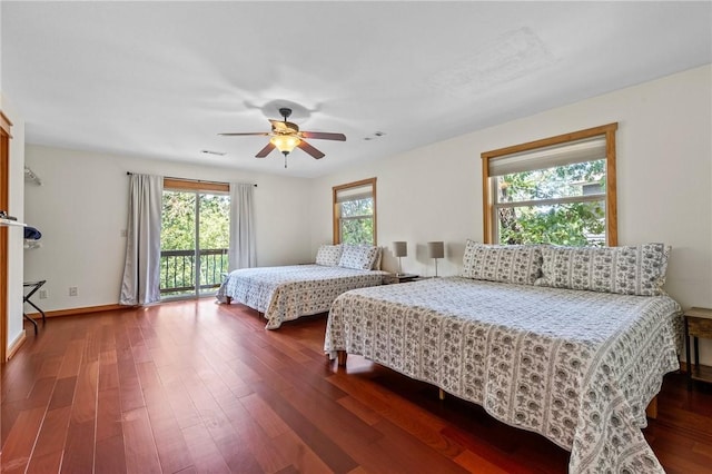 bedroom featuring multiple windows, dark wood-type flooring, a ceiling fan, and access to outside