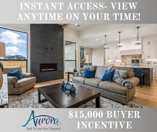 living room featuring light hardwood / wood-style flooring and a large fireplace