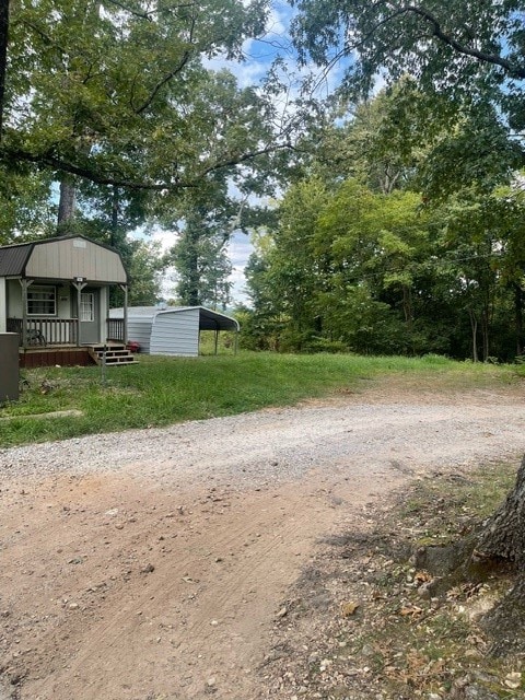 view of yard featuring a porch and a carport