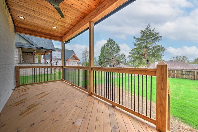 wooden deck featuring ceiling fan and a yard