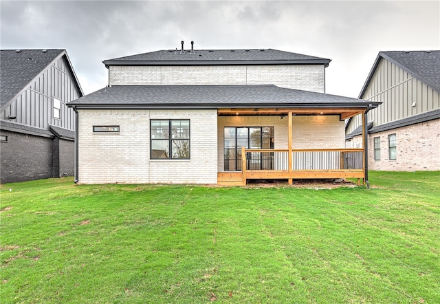 rear view of property featuring a yard and a wooden deck