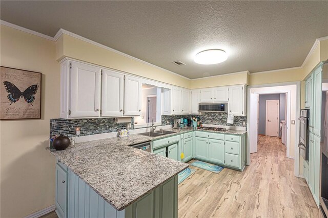 kitchen featuring white cabinets, kitchen peninsula, a textured ceiling, appliances with stainless steel finishes, and green cabinets