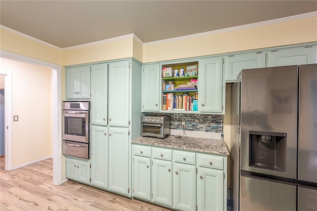 kitchen featuring light stone counters, light hardwood / wood-style floors, tasteful backsplash, stainless steel appliances, and crown molding