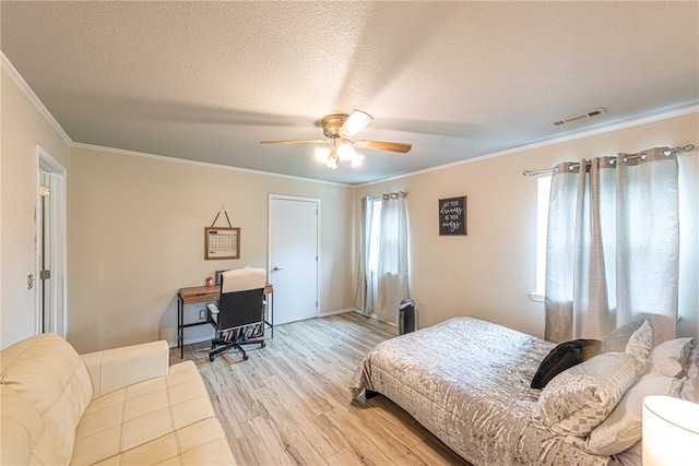 bedroom with ceiling fan, a textured ceiling, crown molding, and light hardwood / wood-style floors