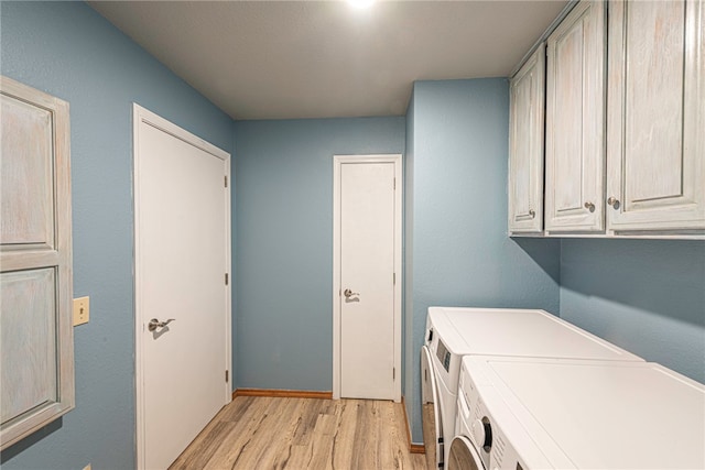 washroom with cabinets, light wood-type flooring, and washer and dryer