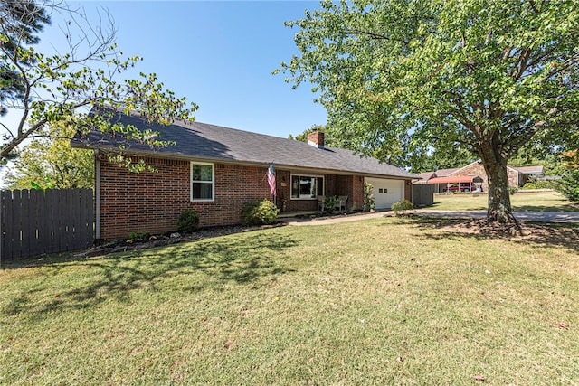 rear view of property with a garage and a lawn