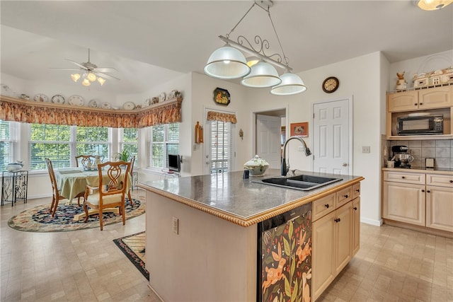 kitchen featuring black appliances, sink, a healthy amount of sunlight, and a center island with sink