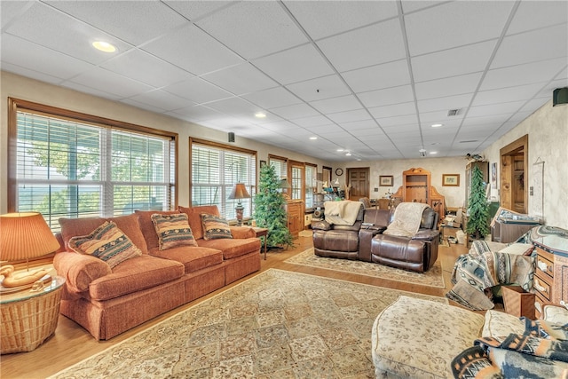 living room with hardwood / wood-style flooring and a paneled ceiling