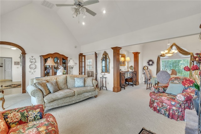 living room with ceiling fan with notable chandelier, light colored carpet, high vaulted ceiling, and decorative columns