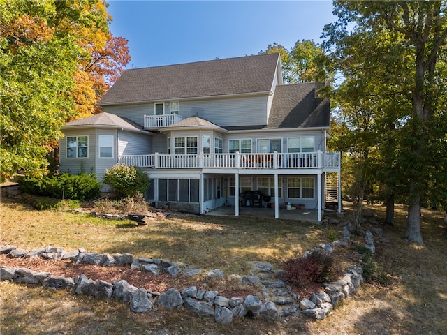 back of house with a balcony, a deck, a patio area, and a sunroom