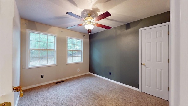 spare room featuring ceiling fan and carpet