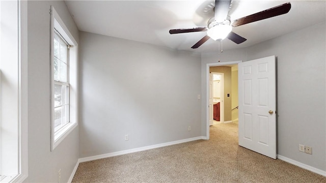 spare room with ceiling fan and plenty of natural light