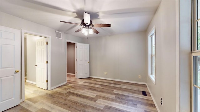 unfurnished bedroom featuring ceiling fan, ensuite bathroom, and light hardwood / wood-style flooring