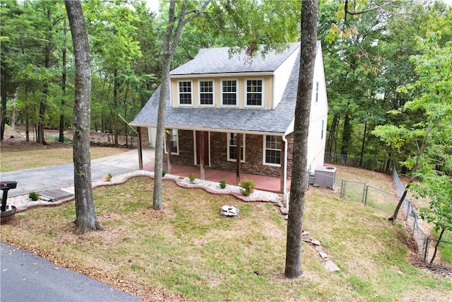11566 Hickory Dr, Garfield, AR 72732 - view of front of home featuring a porch, stone siding, concrete driveway, roof with shingles, and central AC unit