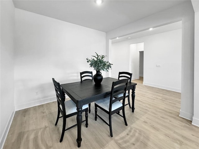 dining room featuring light wood-type flooring and baseboards