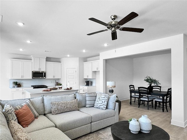 living area with ceiling fan, baseboards, light wood finished floors, and recessed lighting