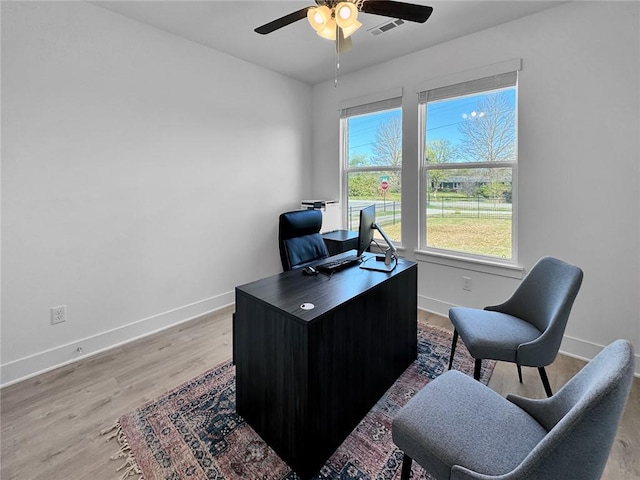 office area featuring ceiling fan, baseboards, visible vents, and light wood finished floors