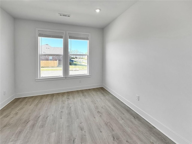 unfurnished room with light wood-type flooring, baseboards, and visible vents