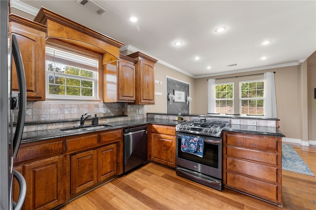 kitchen featuring plenty of natural light, light hardwood / wood-style floors, appliances with stainless steel finishes, and kitchen peninsula