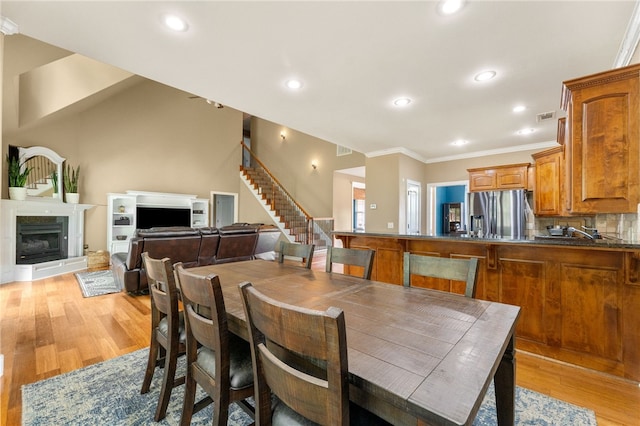 dining room with ornamental molding and light wood-type flooring