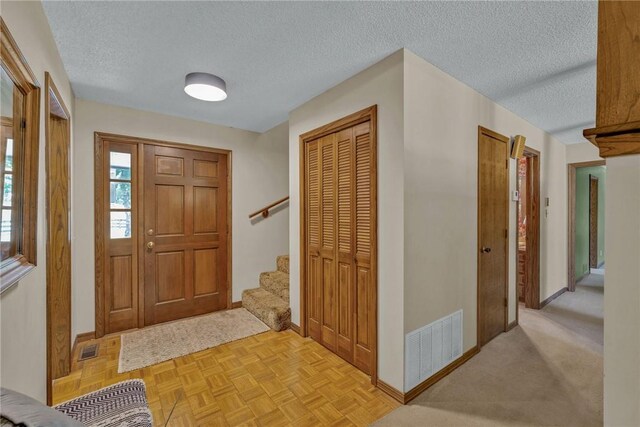 entryway featuring a textured ceiling and light parquet floors