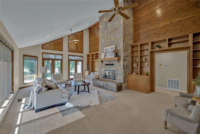 living room featuring high vaulted ceiling, french doors, built in features, a fireplace, and light colored carpet