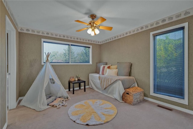 bedroom featuring carpet, ceiling fan, and multiple windows