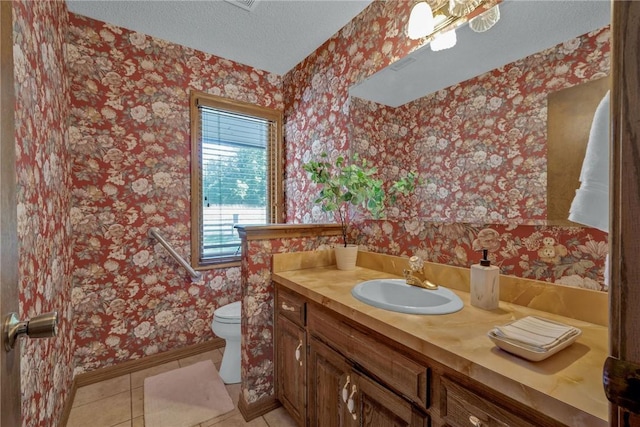 bathroom featuring tile patterned flooring, vanity, toilet, and a textured ceiling