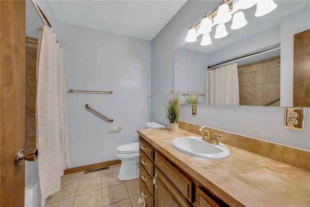 bathroom featuring vanity, tile patterned floors, toilet, a textured ceiling, and walk in shower