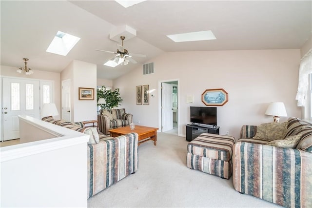 living room with ceiling fan, light colored carpet, and vaulted ceiling with skylight