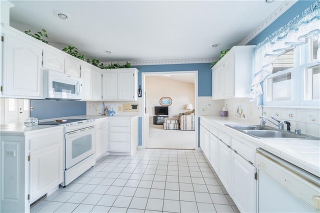 kitchen with white appliances, tile countertops, sink, and white cabinets