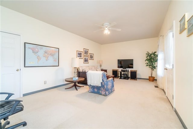 living area with light carpet and ceiling fan