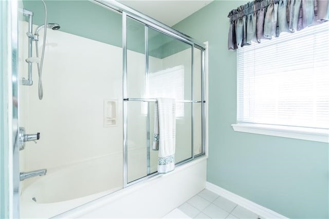 bathroom featuring tile patterned flooring and bath / shower combo with glass door