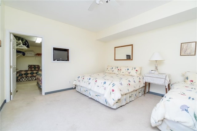 carpeted bedroom featuring a walk in closet, a closet, and ceiling fan