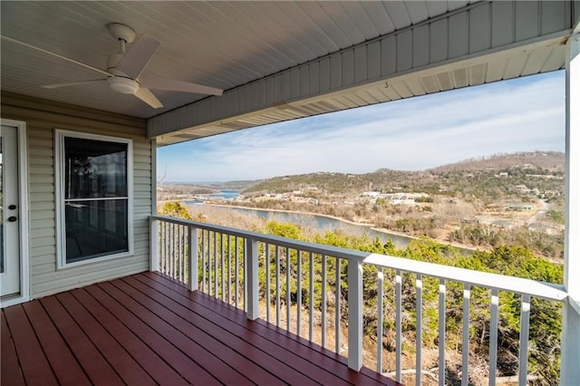 deck with a water view and ceiling fan