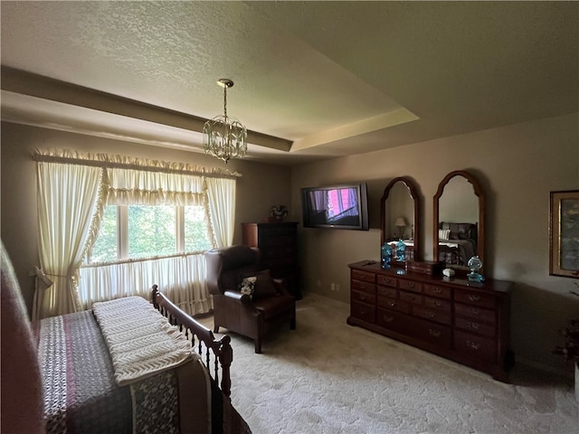 bedroom featuring carpet floors, a textured ceiling, a tray ceiling, and a chandelier