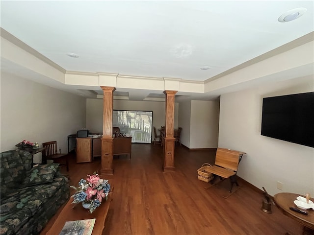 living room featuring a tray ceiling, decorative columns, and dark hardwood / wood-style flooring