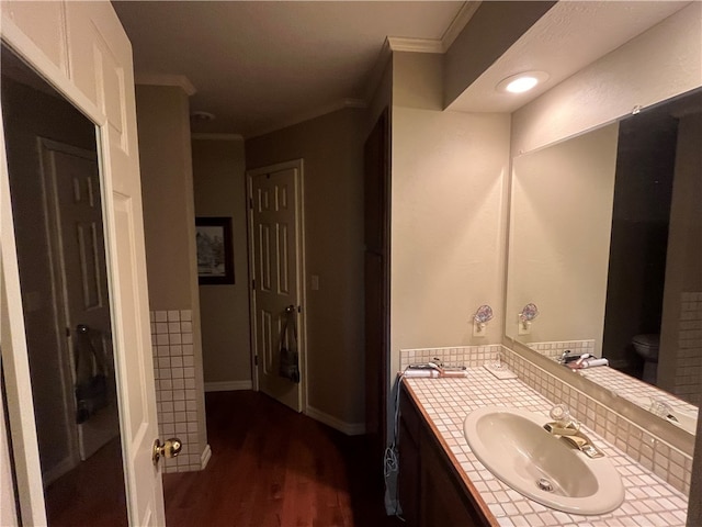 bathroom featuring vanity, toilet, ornamental molding, hardwood / wood-style floors, and decorative backsplash