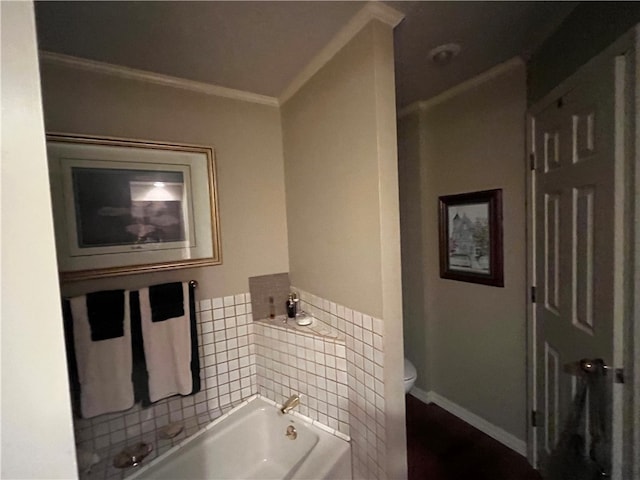 bathroom with a tub to relax in, ornamental molding, and toilet