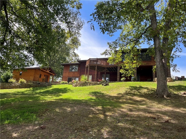 rear view of house with a deck and a yard